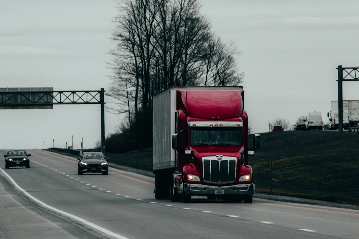 Semi-truck and trailer traveling along a rural highway